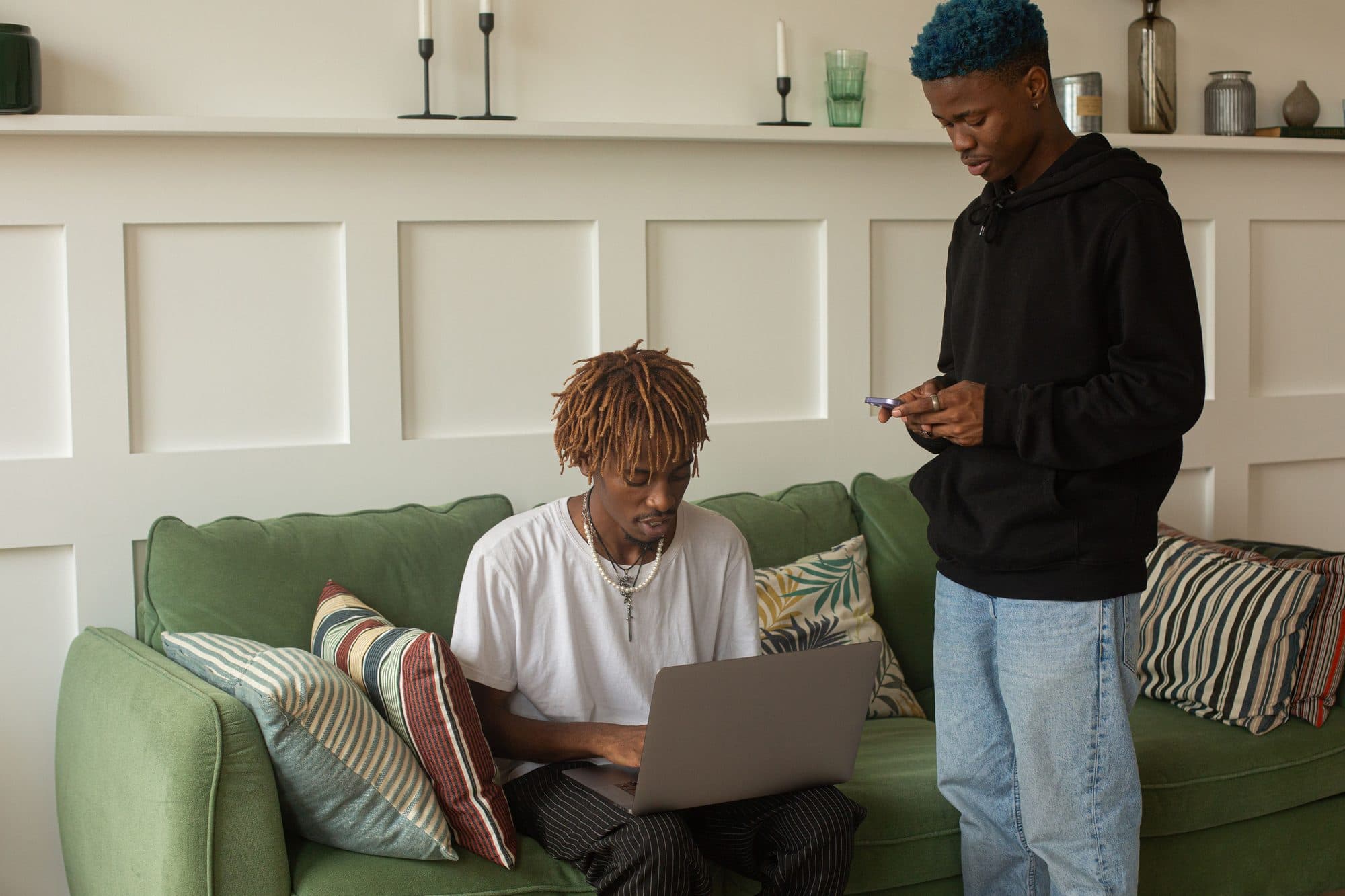 Deux jeunes hommes, l’un sur un ordinateur portable, l’autre sur son téléphone.